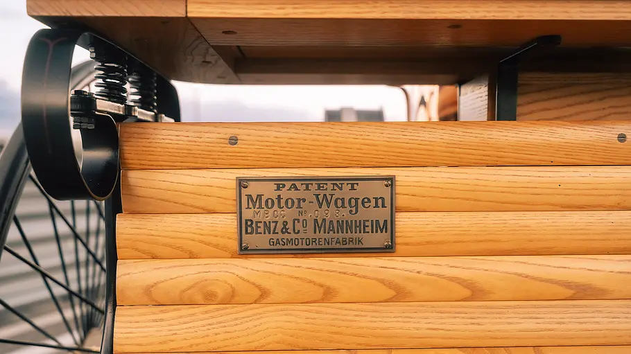 Die Detailaufnahme zeigt ein Schild für das Patent des Fahrzeugs mit Gasmotorenbetrieb.