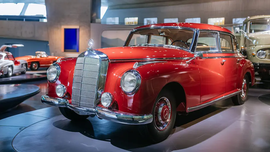 Das Bild zeigt einen Mercedes 300 aus den 50er-Jahren von schräg seitlich, der in einem Museum steht.