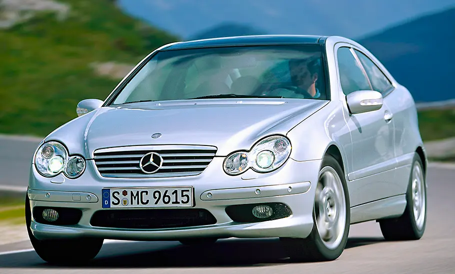 Der Mercedes C 30 CDI AMG Sportcoupé fährt in eine Kurve, von schräg vorne fotografiert.
