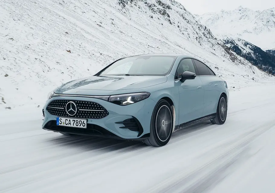 Mercedes CLA Hybrid Fahrendes Auto von schräg vorne auf einer verschneiten Straße.