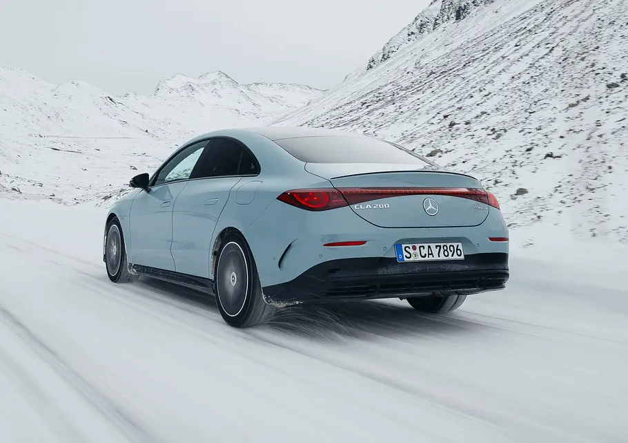 Mercedes CLA Hybrid Fahrendes Auto auf einer verschneiten Straße von hinten.