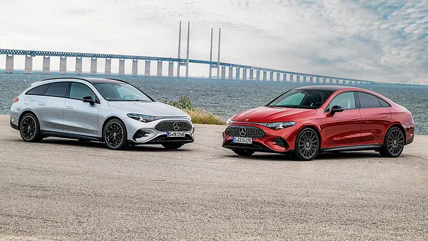 Der Mercedes CLA als Shooting Brake (links) und Limousine, fotografiert von schräg vorne, im Hintergrund die Öresundbrücke. - Foto: Mercedes