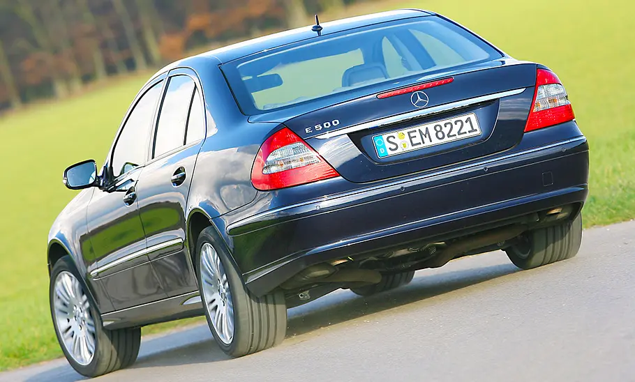 Der Mercedes E 500 fahrend von schräg hinten fotografiert.