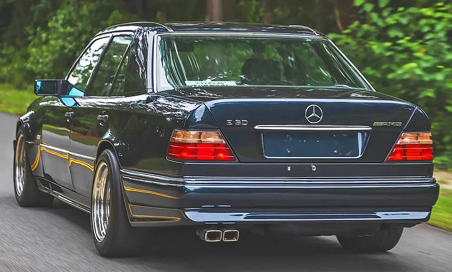 Der Mercedes-Benz E60 AMG (W124) fahrend von schräg hinten