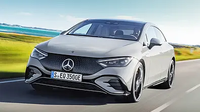 Mercedes EQE (2022) fährt über die Landstraße, von schräg vorne fotografiert. - Foto: Mercedes