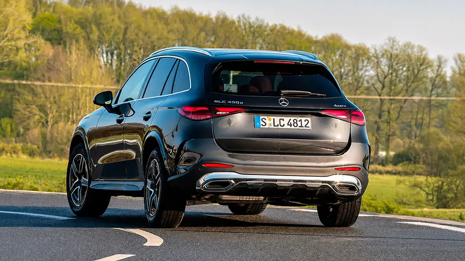 Der Mercedes GLC 450 d 4Matic in einer Linkskurve fahrend von schräg hinten links.