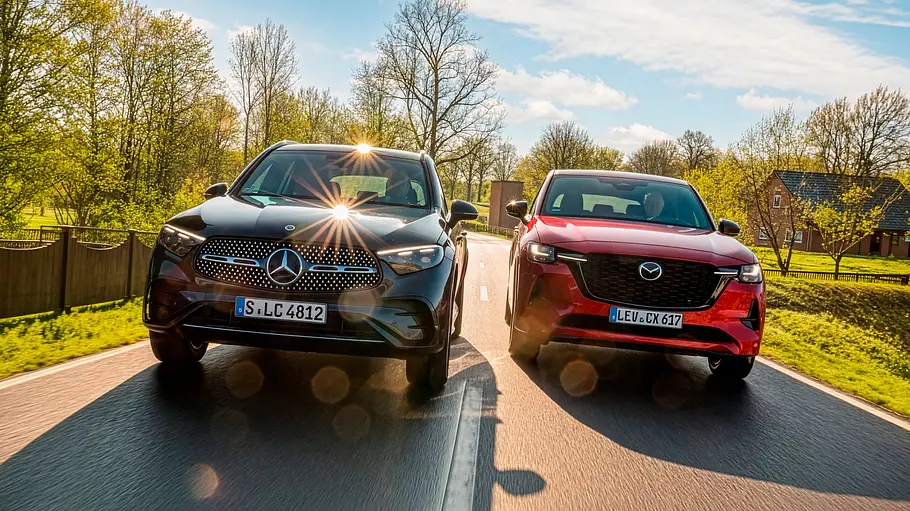 Mercedes GLC 450 d 4Matic und Mazda CX-60 e-Skyactiv D 254 AWD auf einer Landstraße fahrend von vorne.