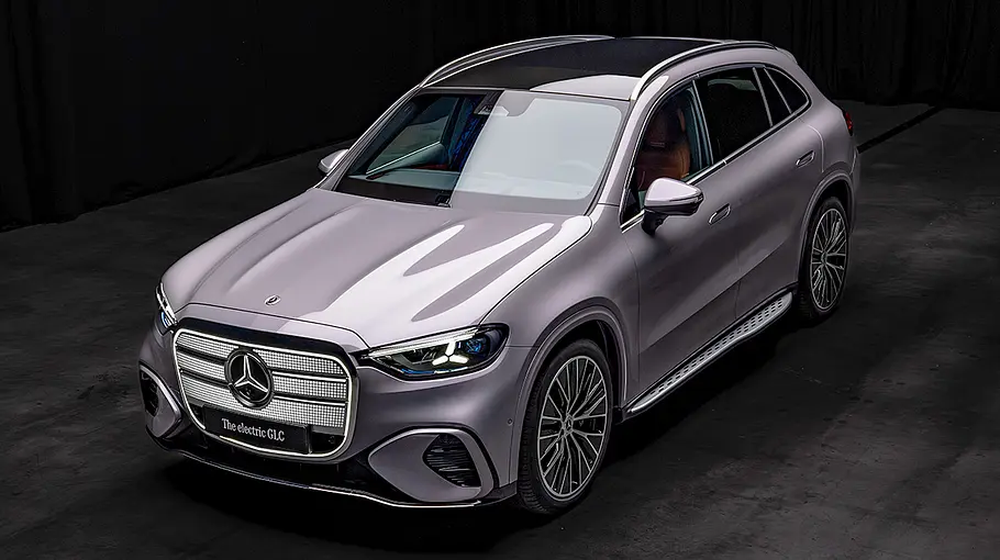 Mercedes GLC EQ Der Mercedes GLC EQ steht vor dunklem Hintergrund, von vorne links fotografiert.