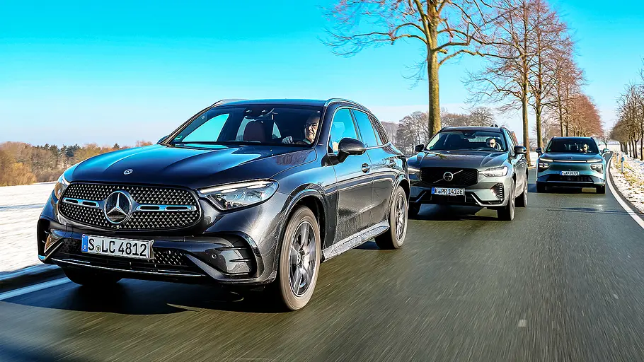Blick von schräg vorne auf die drei fahrenden Mittelklasse-SUV Mercedes GLC, Volvo XC60 und Xpeng G9.
