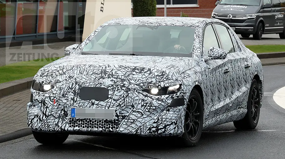 Mercedes E-Klasse EQ Die Mercedes E-Klasse EQ verlässt als Erlkönig einen Kreisverkehr.