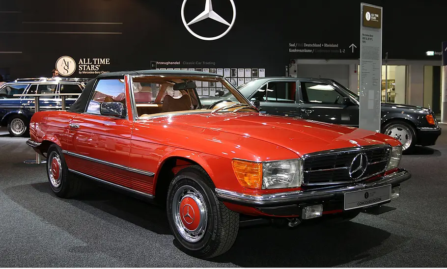 Ein roter Mercedes Benz 280 SL stehend auf einer Messe.