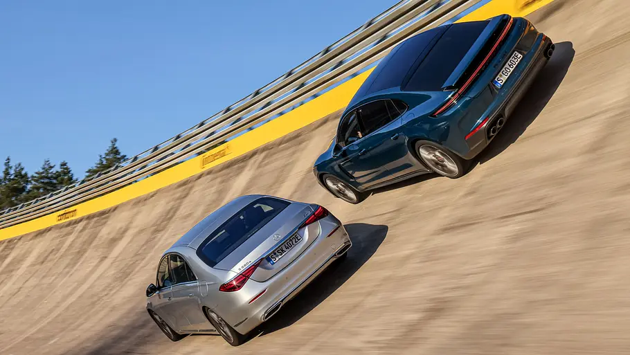 Mercedes S-Klasse Lang und Porsche Panamera Executive fahren nebeneinander durch eine Steilkurve, von hinten fotografiert.