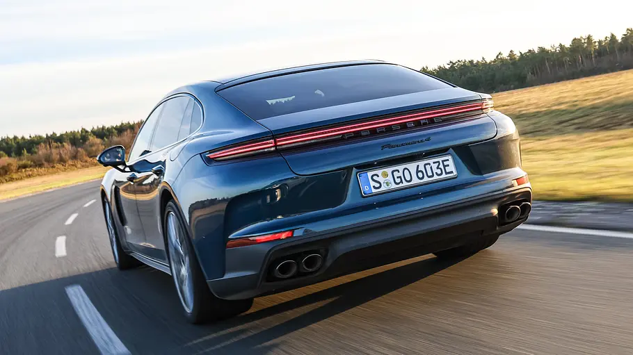 Der Porsche Panamera Executive fährt auf einer Straße, von hinten links fotografiert.