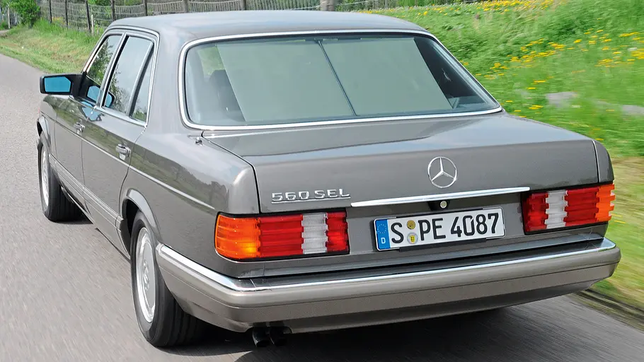 Mercedes 560 SEL Der Mercedes 560 SEL fahrend von hinten.
