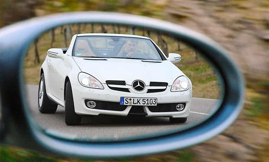Mercedes SLK 200 Kompressor Der Mercedes SLK 200 Kompressor fahrend von schräg vorne im Rückspiegel fotografiert.