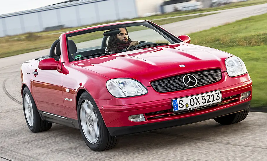 Der Mercedes SLK fahrend mit offenem Verdeck.