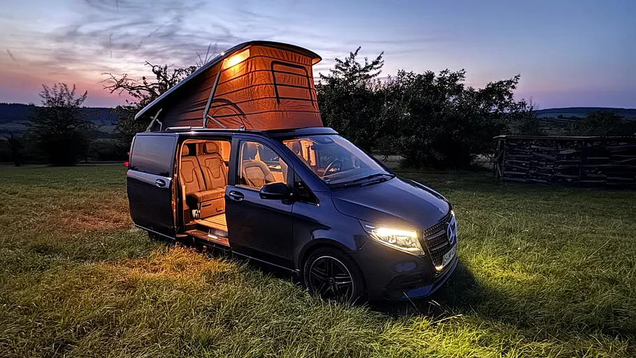 Die Mercedes V-Klasse Marco Polo steht auf einem Campingplatz, schräg seitlich fotografiert.