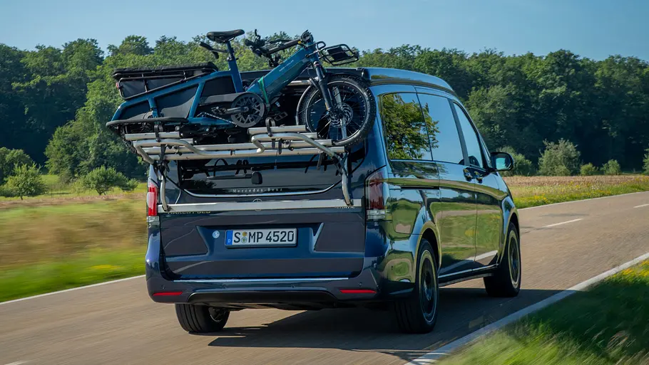 Die Mercedes V-Klasse Marco Polo fährt auf einer Straße, fotografiert von hinten schräg auf.