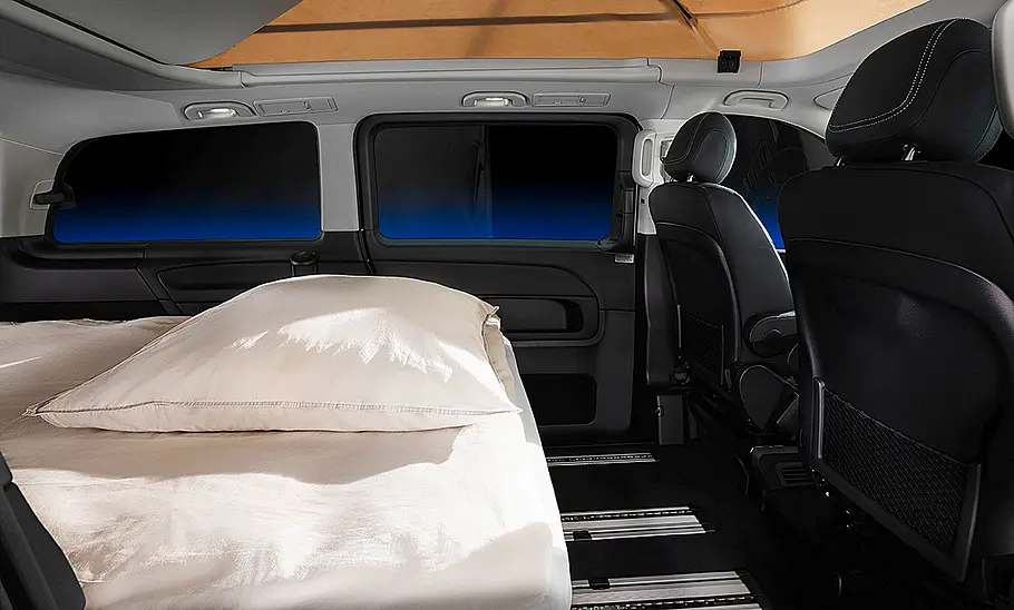 Das Bild zeigt den Innenraum des stehenden Mercedes Marco Polo Horizon in Schlafkonfiguration mit einer zum Doppelbett umgeklappten Rückbank.