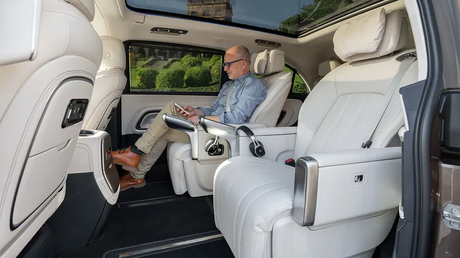 Mercedes VLE 300 im Fahrbericht Tester in mittlerer Sitzreihe des Mercedes VLE, fotografiert von der Seite.
