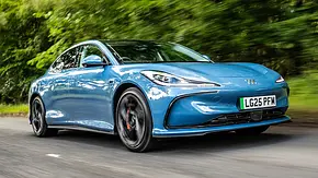 Der MG IM5 (2025) fährt über eine Landstraße durch den Wald, fotografiert von schräg vorne. - Foto: MG