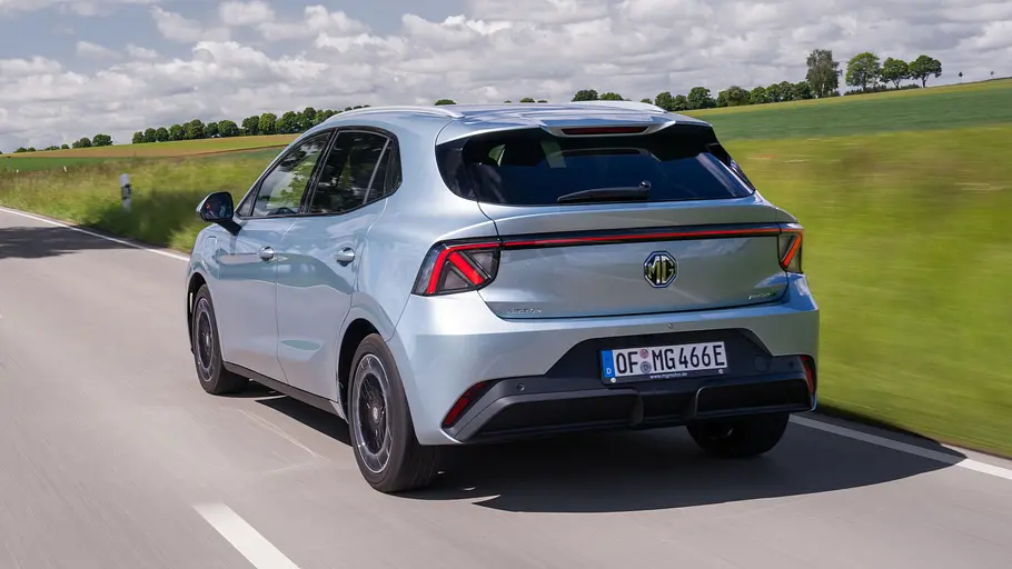 Der MG4 EV Urban fährt auf einer Landstraße, von hinten fotografiert.