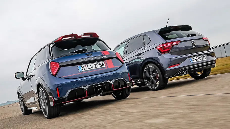Blick von schräg hinten auf den fahrenden Mini Cooper JCW und VW Polo GTI.