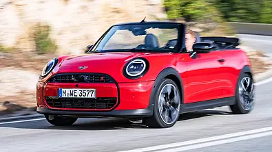 Blick von schräg vorne auf das fahrende Mini Cooper S Cabrio (2025). - Foto: Mini