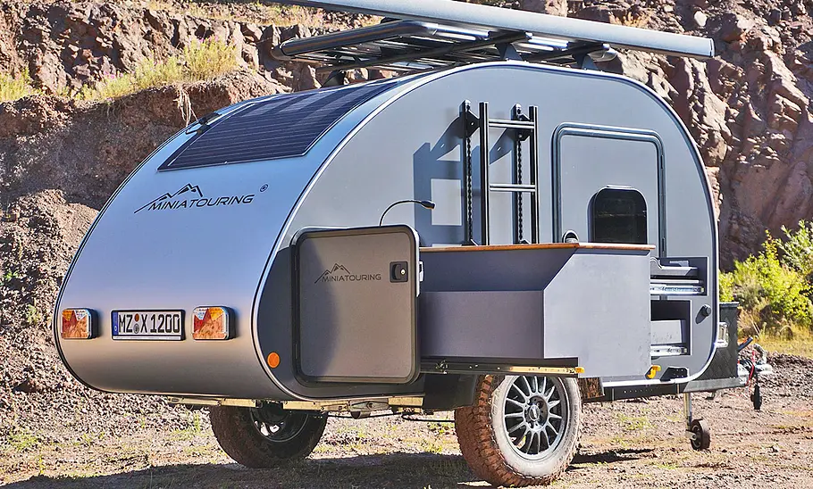 Miniatouring Mini-Caravan M22 (2026) steht im Gelände, ohne Zugfahrzeug. Ansicht von rechts.