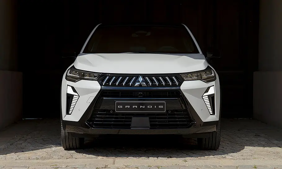 Der Mitsubishi Grandis (2025) in einer Einfahrt stehend von vorne fotografiert.