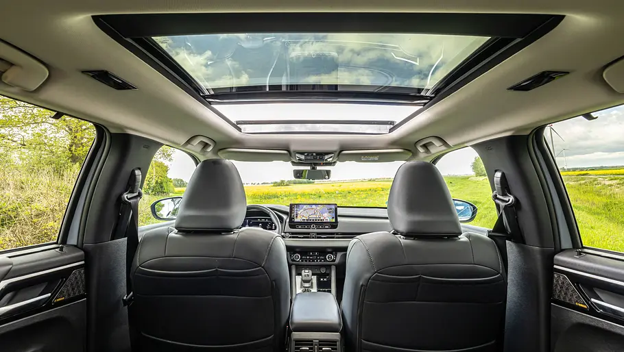 Innenraum und Panoramaglasdach im Mitsubishi Outlander fotografiert von der Rückbank aus.