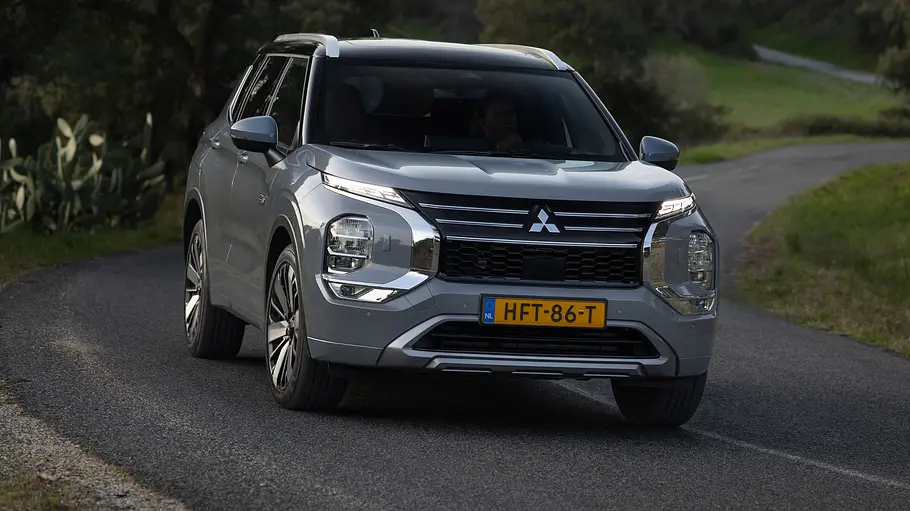 Mitsubishi Outlander Leasing Der Mitsubishi Outlander durch eine Linkskurve fahrend von schräg vorne rechts.