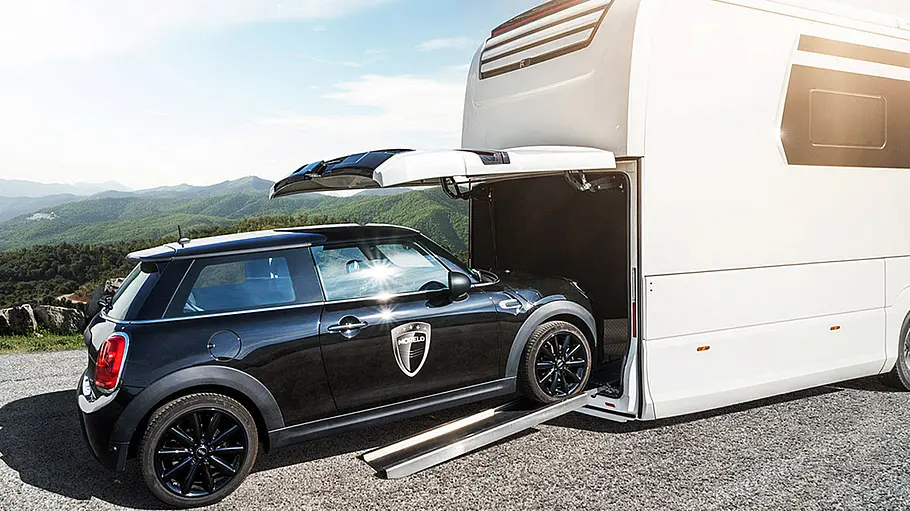 Morelo Empire 110 GSB Die Außenaufnahme zeigt einen Kleinwagen vom Typ Mini, der in die Heckgarage des Morelo Empire 110 GSB gefahren wird.