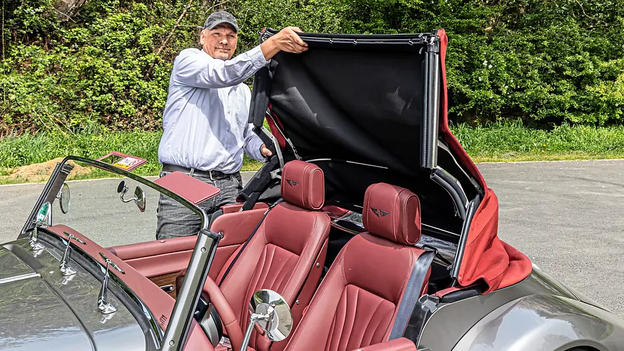 Tester mit dem Verdeck des Morgan Supersport im Test, fotografiert von der Seite.