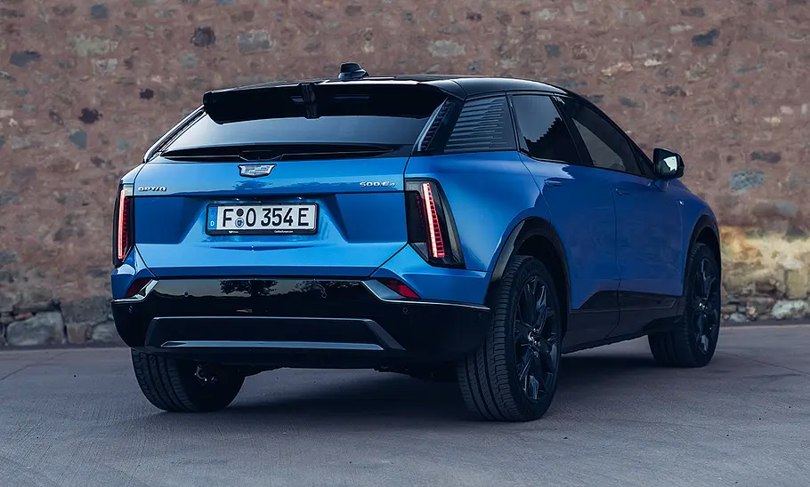Der Cadillac Optiq (2026) steht schräg vor einer Wand, fotografiert von hinten.