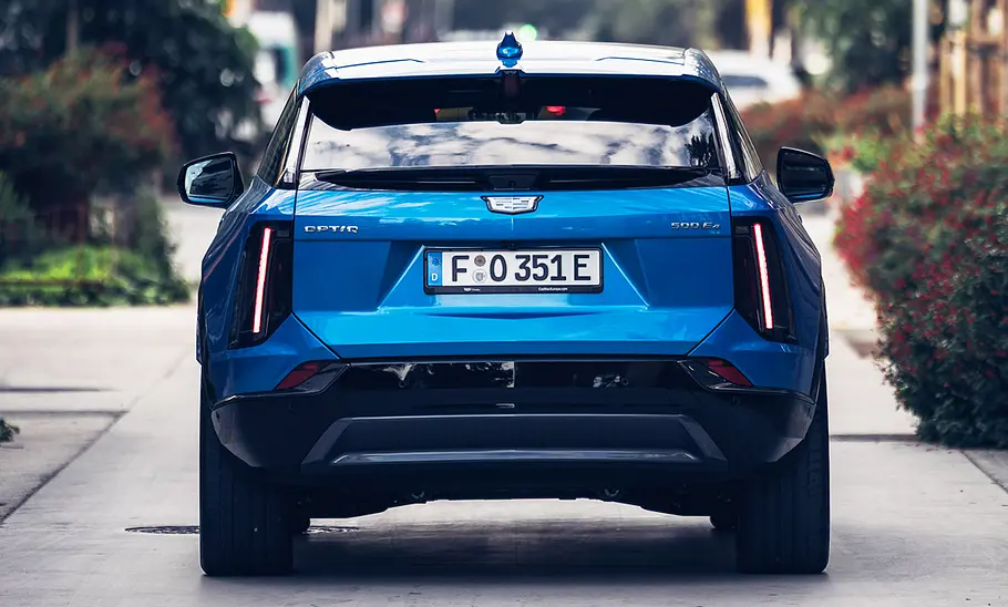 Der Cadillac Optiq (2026) steht auf einer Straße, fotografiert von hinten.