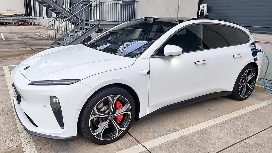 Nio ET5 Der Nio ET5 steht auf einem Parkplatz und lädt an einer Wallbox.