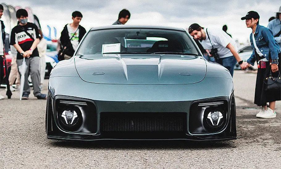 Blick von vorne auf den 350Z Slantnose, daneben stehen Menschen und schauen auf das Fahrzeug.