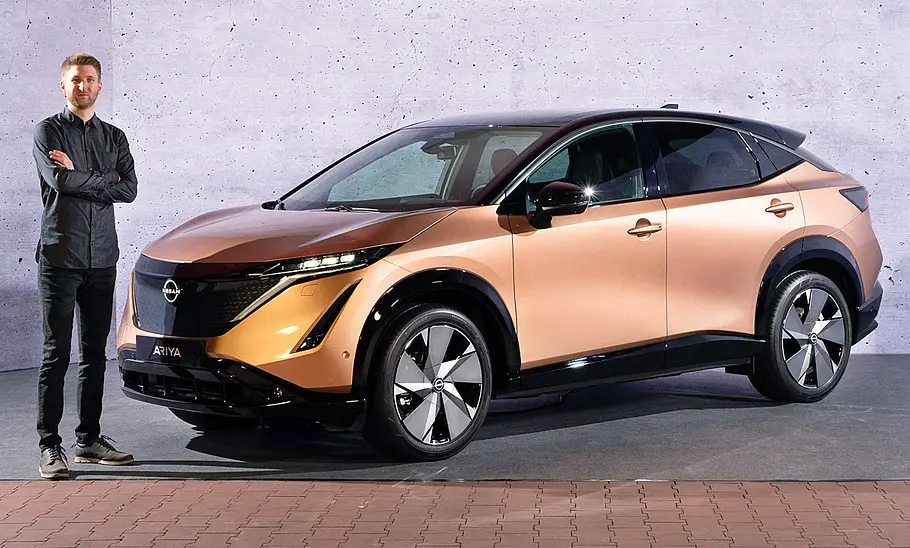 Nissan Ariya (2022) Nissan Ariya (2022); Blick von vorne auf das stehende SUV. Mit AUTO ZEITUNG-Chefredakteur Alexander Koch.