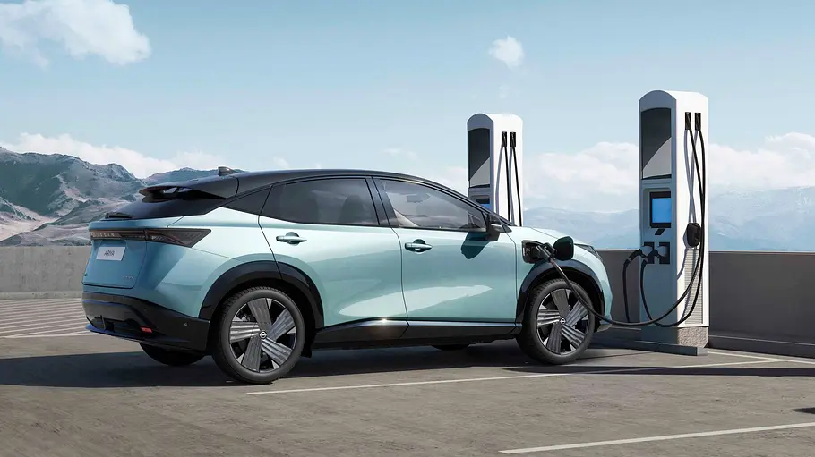 Das Nissan Ariya Facelift (2026) steht von schräg hinten rechts zu sehen an einer Ladesäule.