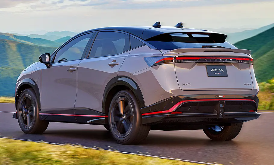 Nissan Ariya Nismo (2024) Nissan Ariya Nismo (2024); Blick von hinten auf das fahrende SUV.