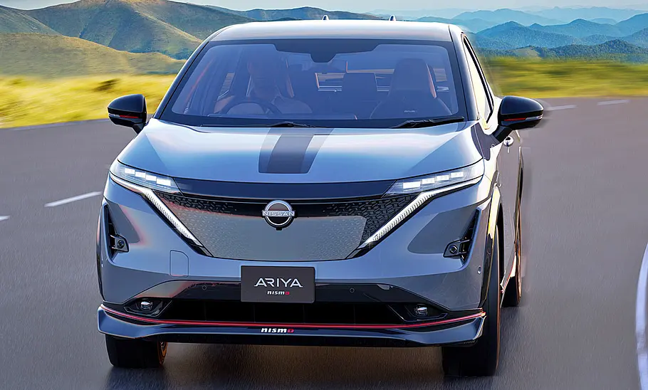 Nissan Ariya Nismo (2024) Nissan Ariya Nismo (2024); Blick von vorne auf das fahrende SUV.