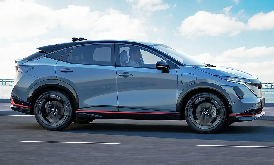 Nissan Ariya Nismo (2024) Nissan Ariya Nismo (2024); Blick von der Seite auf das fahrende SUV.