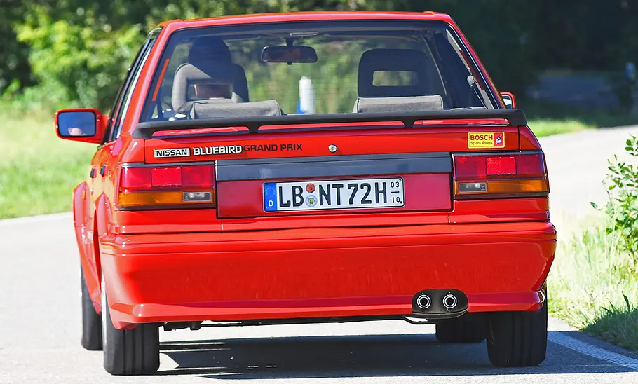 Nissan Bluebird Grand Prix 1.8i 16V Der Nissan Bluebird Grand Prix 1.8i 16V fahrend von hinten.