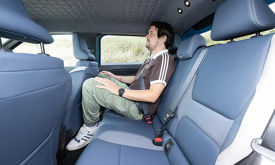 AUTO ZEITUNG-Redakteur Sven Kötter auf der Rücksitzbank des Nissan Micra (2026), fotografiert von der Seite.