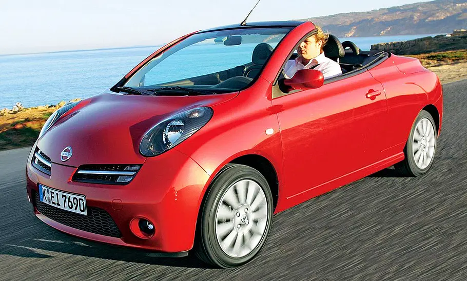 Der Nissan Micra C+C fahrend mit offenem Verdeck.