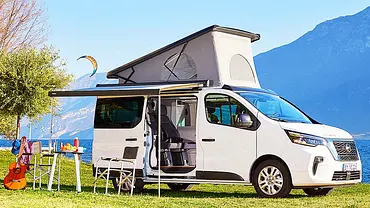 Die Außenaufnahme zeigt den stehenden Nissan Primastar Seaside by Dethleffs (2022) von schräg seitlich mit ausgefahrenem Aufstelldach. - Foto: Nissan Die Außenaufnahme zeigt den stehenden Nissan Primastar Seaside by Dethleffs (2022) von schräg seitlich mit ausgefahrenem Aufstelldach. - Foto: Nissan