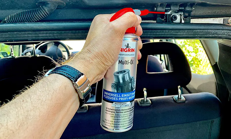 Nigrin Performance Multi-Öl Eine Hand im Auto mit dem Nigrin Performance Multi-Öl.