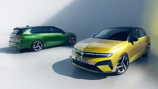 Der Opel Astra Electric (rechts) und Opel Astra Electric Sports Tourer (links) statisch vor einer weißen Wand. - Foto: Opel