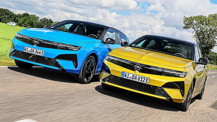 Blick von schräg vorne auf die beiden fahrenden Kompakten Opel Astra Electric und Opel Astra Plug-in-Hybrid.